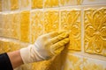 hands of the tiler are laying yellow ceramic tile on the wall. ai generated