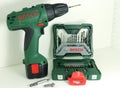 A professional tools of Bosch - one green cordless drill accumulator drill and a set of drill bits.