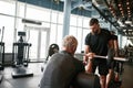 Professional trainer carefully choosing workout activities for aged man Royalty Free Stock Photo