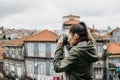 A professional travel photographer or tourist photographs a beautiful cityscape in Porto in Portugal. Professional