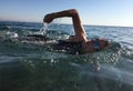 Professional triathlete practicing in open water. Swimming in se