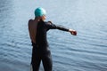 Professional triathlete before swimming in river& x27;s open water. Man wearing swim equipment practicing triathlon on the Royalty Free Stock Photo