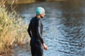 Professional triathlete swimming in river's open water. Man wearing swim equipment practicing triathlon on the beach in Royalty Free Stock Photo