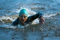 Professional triathlete swimming in river's open water. Man wearing swim equipment practicing triathlon on the beach in Royalty Free Stock Photo