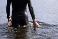 Professional triathlete before swimming in river& x27;s open water. Man wearing swim equipment practicing triathlon on the Royalty Free Stock Photo