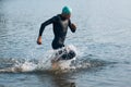 Professional triathlete swimming in river& x27;s open water. Man wearing swim equipment practicing triathlon on the beach in Royalty Free Stock Photo