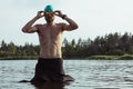 Professional triathlete swimming in river& x27;s open water. Man wearing swim equipment practicing triathlon on the beach in Royalty Free Stock Photo