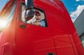 Professional Trucker Behind the Semi Tractor Truck Wheel Royalty Free Stock Photo