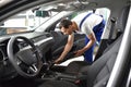 Professional vehicle preparation in a car wash - worker sucks up