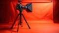 Professional video camera setup on a tripod against a vibrant orange backdrop Royalty Free Stock Photo