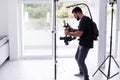 Professional videographer with gimball video slr recording video at home