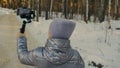 Professional Videographer Holding DSLR Camera on 3-axis Gimbal Stabilization Device in Winter. Cinematographer Operator