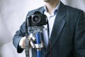 Professional videographer keeps steadicam with camera on white background. Royalty Free Stock Photo