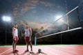 Professional volleyball players in action on the night court