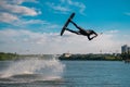 Professional wakeboarder performing jump over water while holding on tow rope Royalty Free Stock Photo