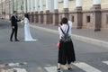 Professional wedding photographer in the process of photographing with the newlyweds in nature Royalty Free Stock Photo