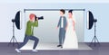 Professional wedding photographer shooting on camera newly weds couple bride and groom embracing posing in modern photo Royalty Free Stock Photo