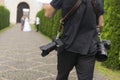 Professional wedding photographer takes pictures of the bride and groom in garden, the photographer in action with two Royalty Free Stock Photo