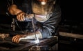 Professional welder in mask welds steel with electric torch tool Royalty Free Stock Photo