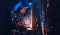 Professional welder performs welding work on metal in protective mask. Industrial worker concept Royalty Free Stock Photo