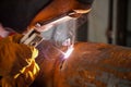 A professional welder welds a pipe with a diameter of DN250 for a process pipeline and corrects defective sections of the seam for