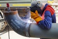 A professional welder works by manual-arc welding with an electrode, and receives a weld of technological pipelines DN 250 for an