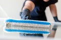 Professional window cleaner using a window cleaning washer sleeve to cleanse a large fold down apartment window