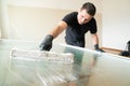 Professional window cleaner using a window cleaning washer sleeve to cleanse a large fold down apartment window Royalty Free Stock Photo