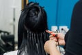 Professional woman applying hair extensions with a special lacer. Royalty Free Stock Photo