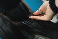 Professional woman applying hair extensions with different types of grips. Royalty Free Stock Photo