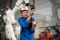 Professional woman check the robotic arm machine in the factory. Worker wearing safety helmet, glasses and uniform. Preventive Royalty Free Stock Photo