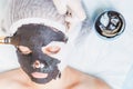 Professional woman, cosmetologist in spa salon applying mud face mask Royalty Free Stock Photo