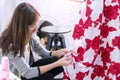 Professional woman fashion designers adjusting dress on model in studio. Dressmaker female sew the hems to clients at