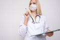 Professional woman medical physician doctor white uniform with stethoscope and prescription board, reading a case history