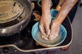 Professional woman potter washing her hands from clay in a hand made ceramic plate. Finished work on the next item vase, cup, mug Royalty Free Stock Photo