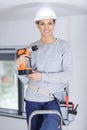 professional woman on stepladder holding cordless power-tool Royalty Free Stock Photo