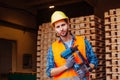 Professional woodworker in hardhat holding pneumatic hammer