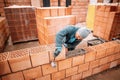 Professional worker building house walls with bricks and masonry details