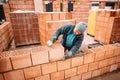 Professional worker building house walls with bricks and masonry details