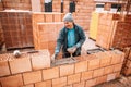 Professional worker building house walls with bricks and masonry details