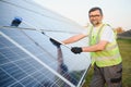 Professional worker cleaning solar PV panel. Man making sure solar batteries in good condition Royalty Free Stock Photo