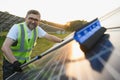 Professional worker cleaning solar PV panel. Man making sure solar batteries in good condition Royalty Free Stock Photo