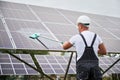 Professional worker cleaning solar PV panel. Royalty Free Stock Photo