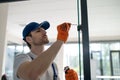 Worker fitting handles and locks on glass partition Royalty Free Stock Photo