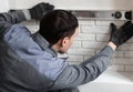 Professional worker gluing a tile on wall