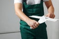 Professional worker holding putty knives with plaster indoors, closeup. Space for text