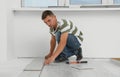 Professional worker installing new laminate flooring indoors Royalty Free Stock Photo