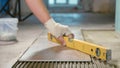 Professional worker laying tiles on floor