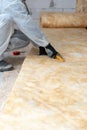 Professional worker in overalls working with rockwool insulation material
