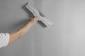 Professional worker plastering wall with putty knife, closeup Royalty Free Stock Photo